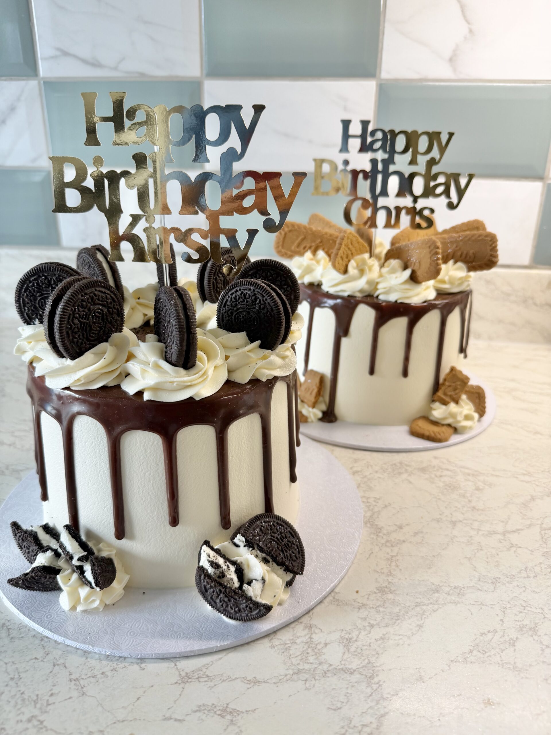 Cake topped with chocolate drip, white frosting rosettes, and Oreo cookies under a 'Happy Birthday' topper; two tiered festive cake with cookies and cookies-and-cream decorations.