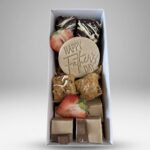 Gift box of assorted chocolates with strawberries and a round 'Happy Father's Day' disk at the center