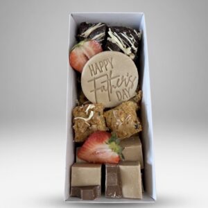 Gift box of assorted chocolates with strawberries and a round 'Happy Father's Day' disk at the center